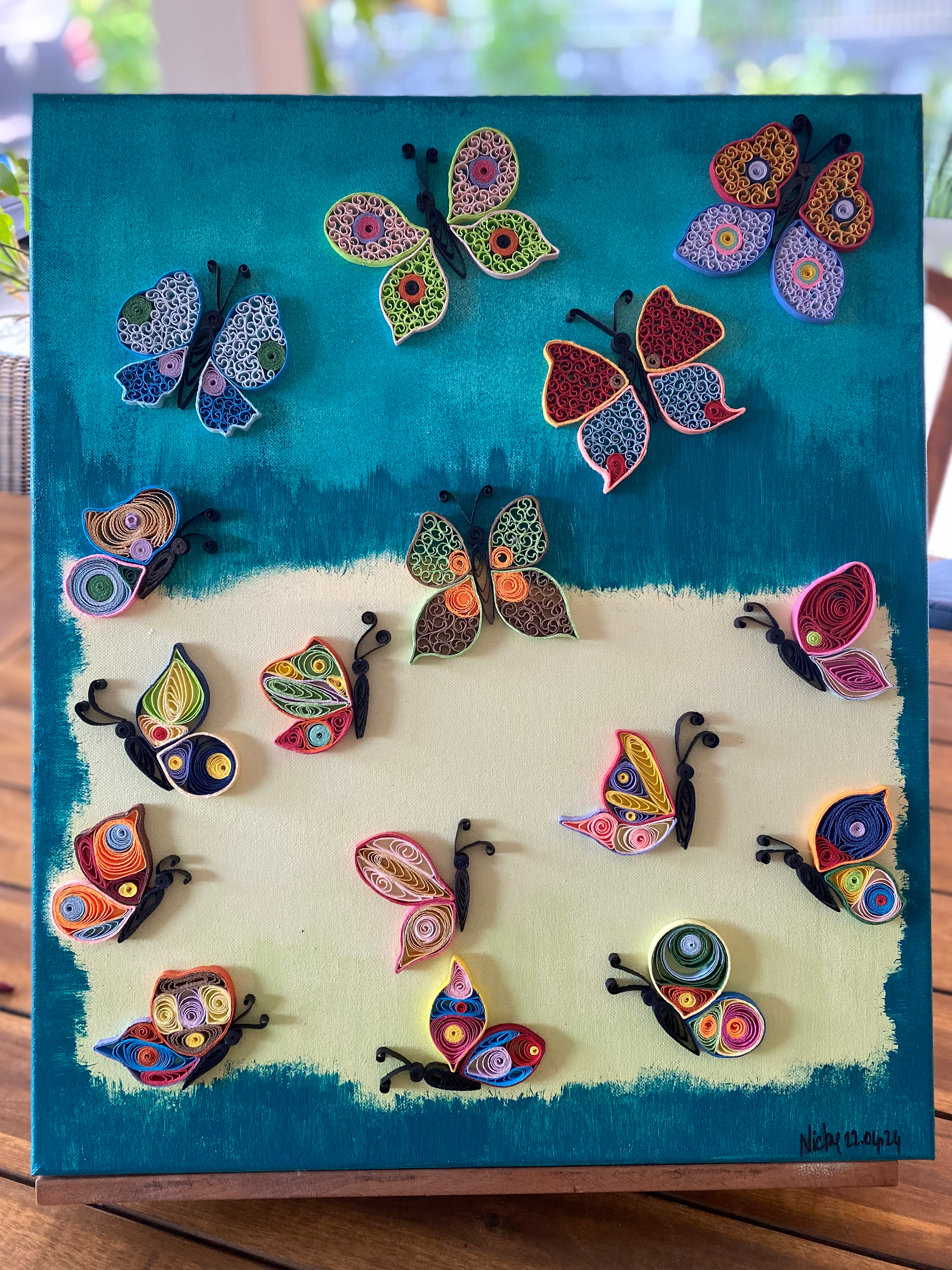 Papillons colorés faits de papier sur fond turquoise et jaune Nicole Louviers Artiste.