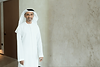 Executive coach and keynote speaker Saeed Alghafri smiling, wearing a white kandura and ghutra against a neutral background