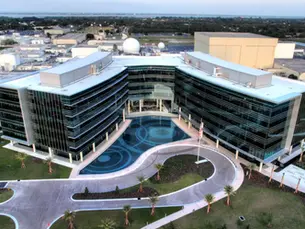 Modern industrial aerospace facility exterior with large building and parking lot