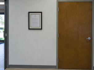 Framed certificate hanging beside a doorway in a commercial lobby