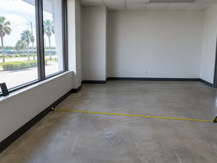 Tape measure across the floor of an empty commercial space during a tour