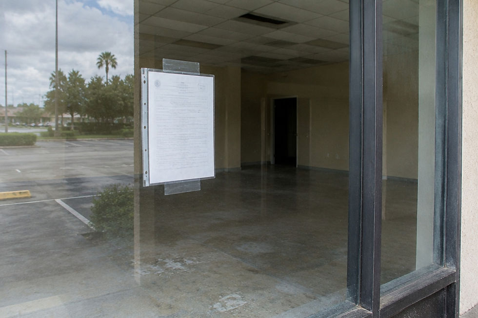 Permit card taped in a storefront window of an empty commercial unit