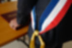 Symbole de l’autorité municipale, l’écharpe tricolore rappelle aussi les devoirs juridiques qui accompagnent un mandat local, dès la phase de candidature.