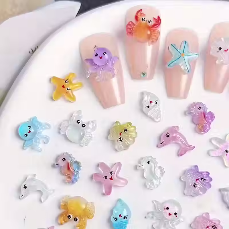 Thumbnail: Close-up van mini zeesterren, krabben en schelpen van hars, perfect voor knutselprojecten en oceaan-thema decoratie