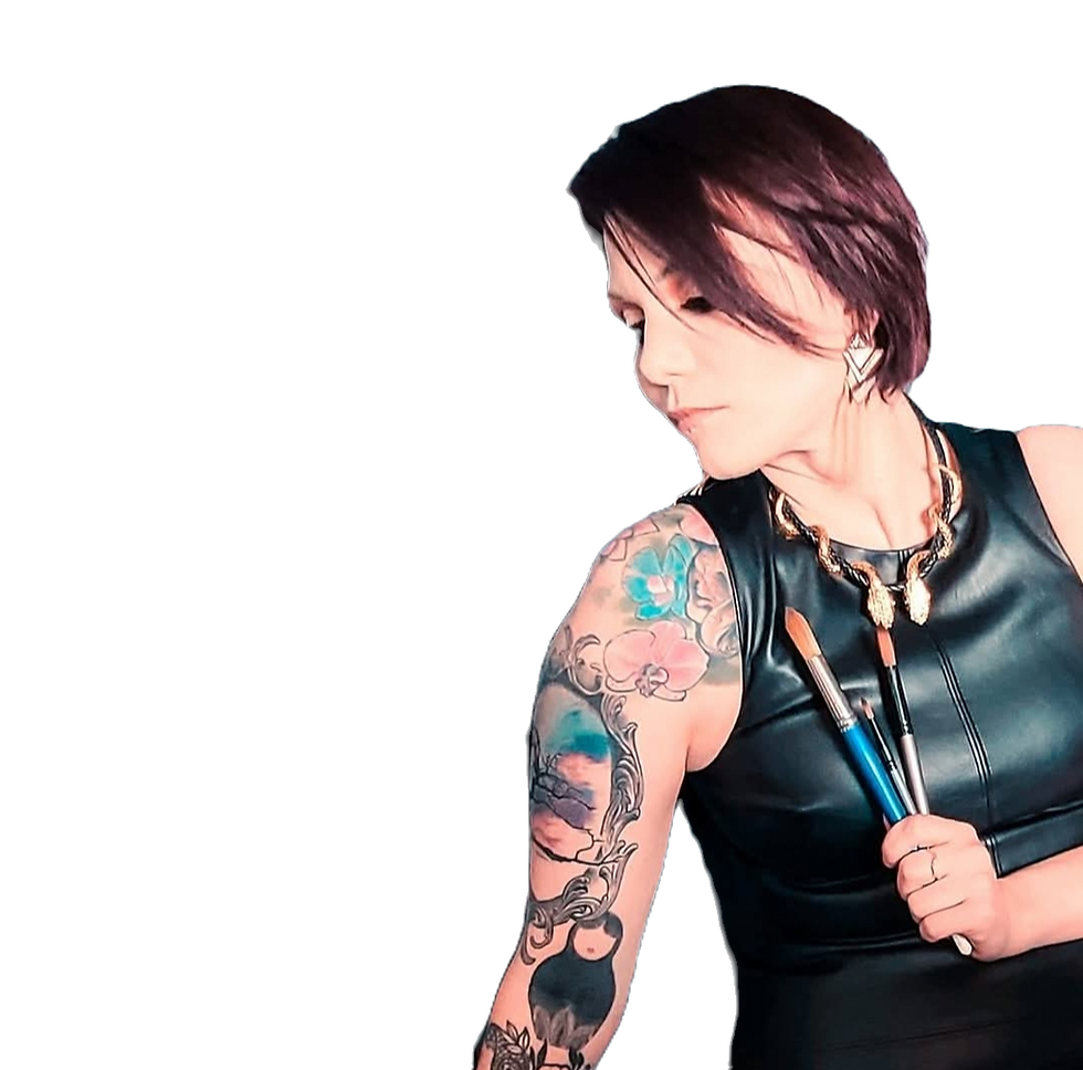 Tattooed person in a black outfit holds paintbrushes against a dark background, exuding a creative and focused mood.