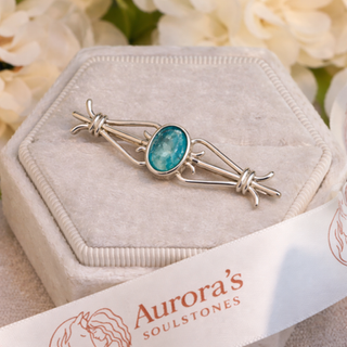 A silver celtic stockpin with small oval resin central stone holding ashes