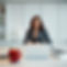 a female CEO in a white office with a red hearted shaped apple on their desk.jpg