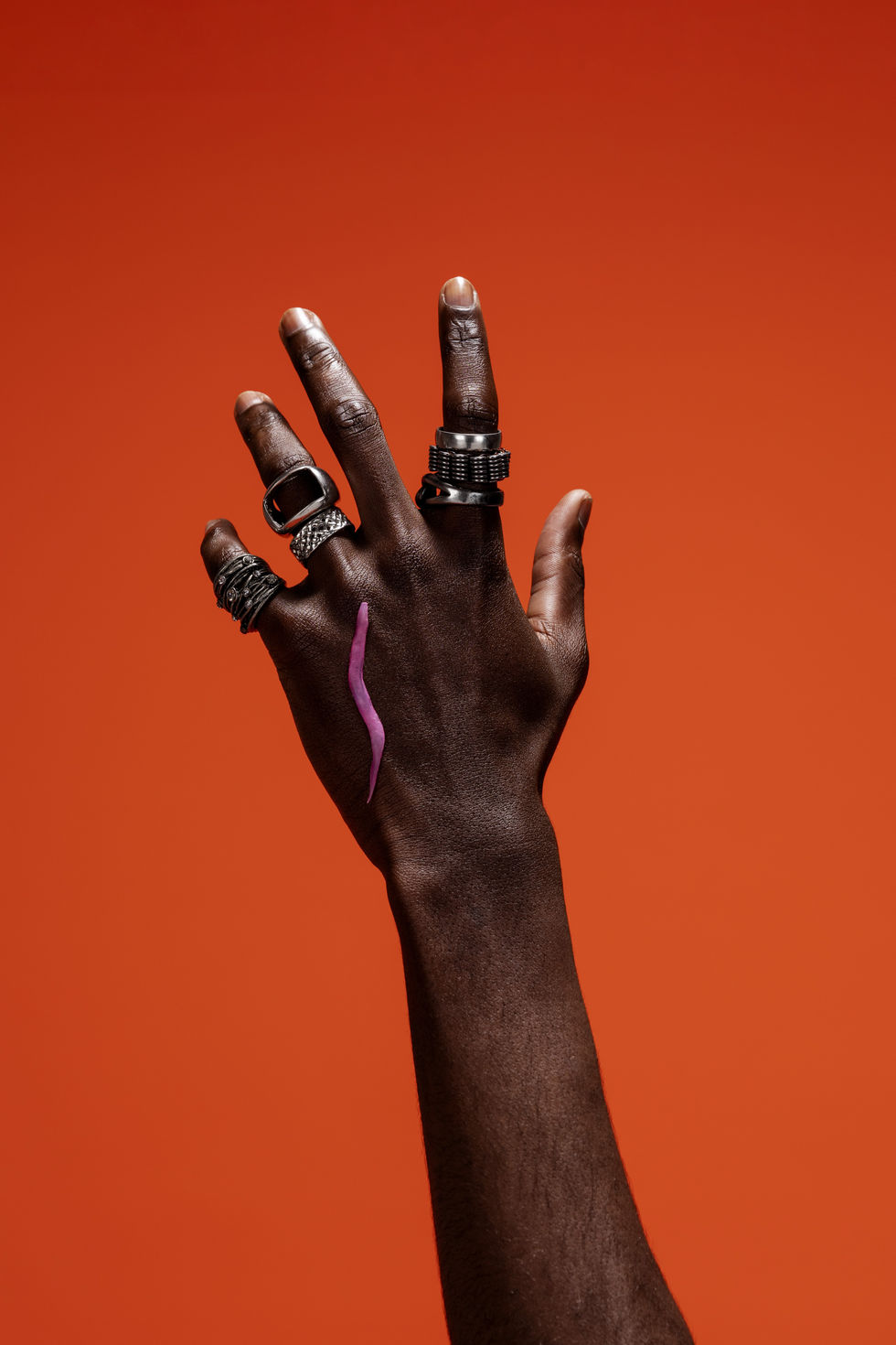 a close up of a hand with many rings on it