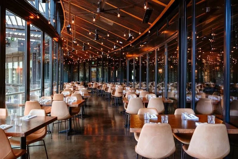 Long dining room with floor-to-ceiling windows at La Loma McGregor Square in Denver