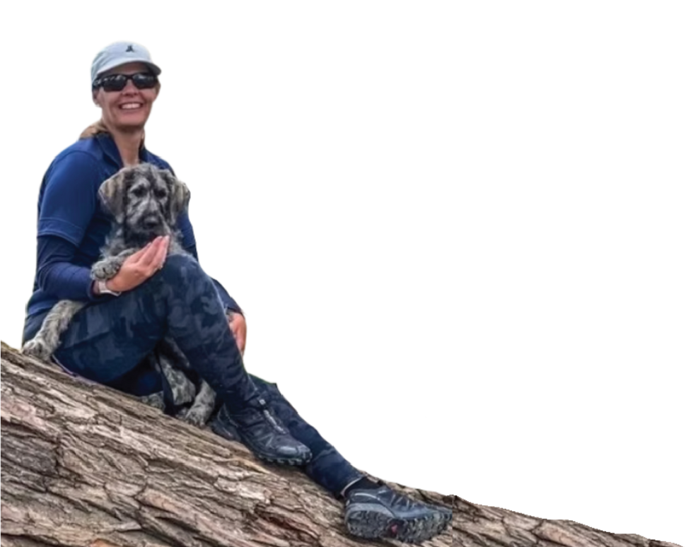 Trainer Melanie smiling with a small dog on her lap, showcasing trust and connection