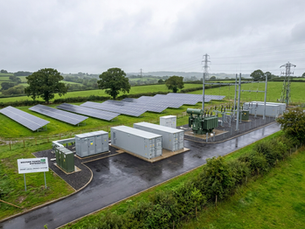 Solar panels and battery storage infrastructure representing a UK microgrid installation combining local generation, energy storage and EV charging canopy with FRP structural profiles, cable trays and grating providing non-conductive corrosion-resistant secondary infrastructure across a 25-year operational life