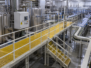Food and beverage processing facility infrastructure showing industrial production environment where FRP moulded grating cable trays and structural profiles provide corrosion-resistant hygiene-compatible non-shedding secondary infrastructure compliant with UK food safety regulations across a 25-year operational design life