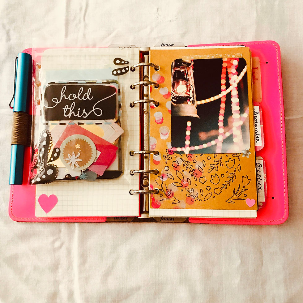 Pink Filofax planner open on a while cloth.