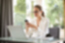 woman in professional clothes wearing glasses and typing on phone