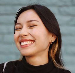 woman in black sweater smiling with eyes closed