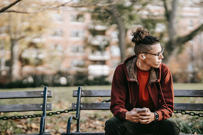 man wearing glasses sitting on bench