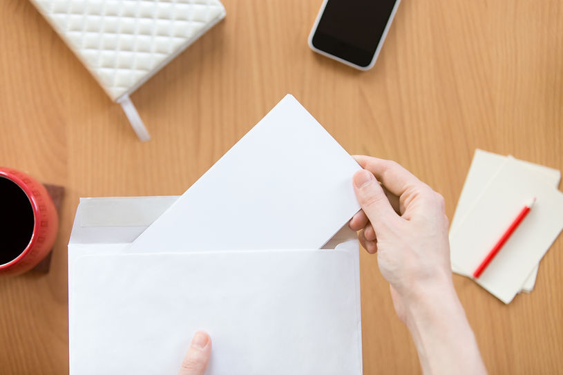 female-hands-holding-an-envelope-with-sheet-over-the-office.jpg