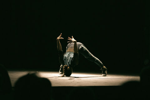 A break dancer performing a physical feat of balancing on their head.