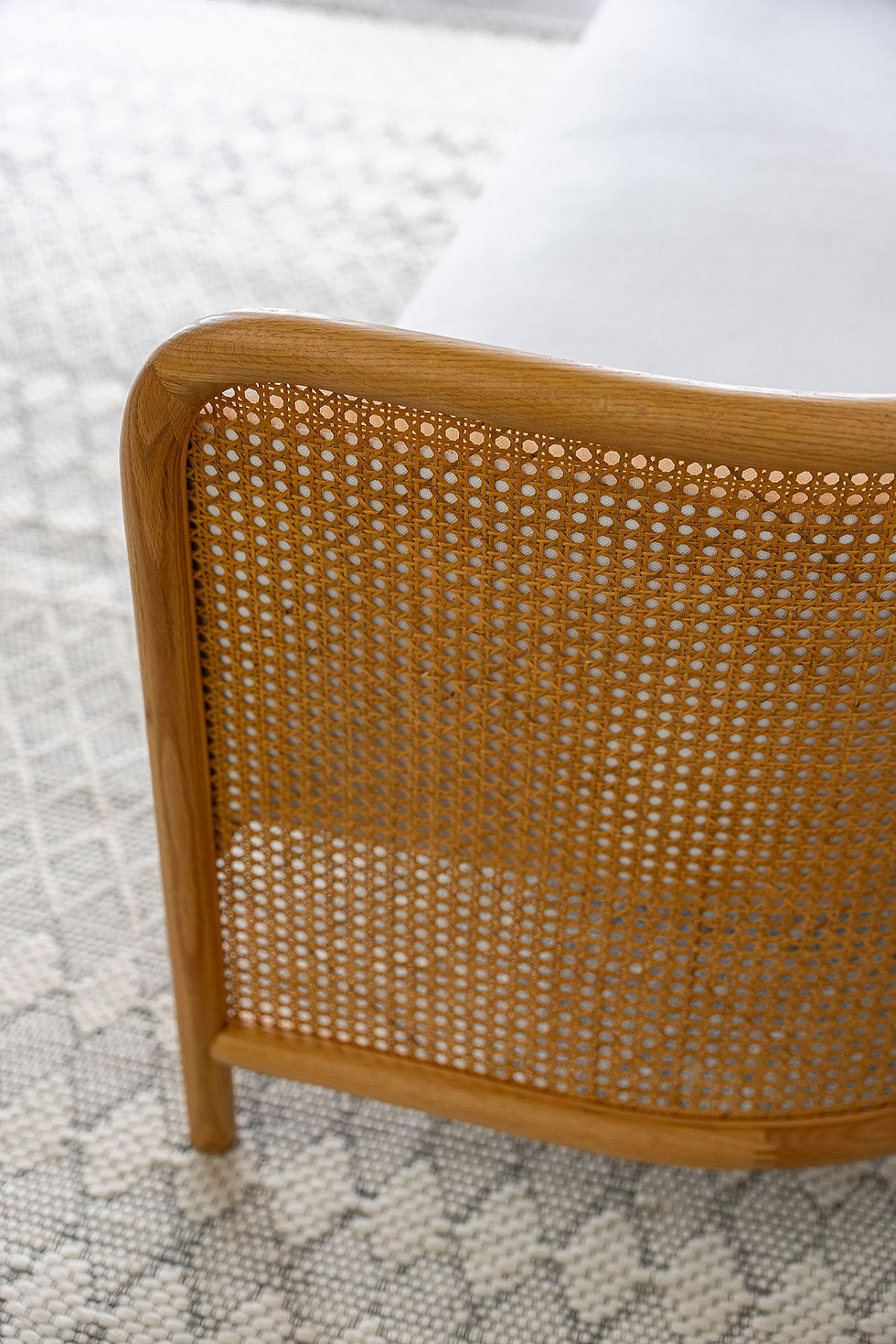 Cane indoor/outdoor sofa honey oak rattan white cushions detail arm view