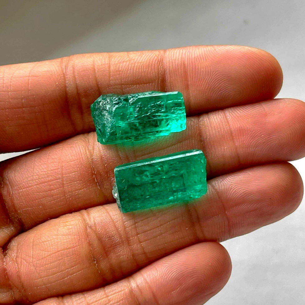 Rahul Jain holding two large pieces of Colombian emerald rough stones unnatural light
