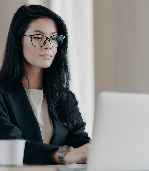 Female financial professional working at a laptop, symbolizing focus, clarity, and executive leadership