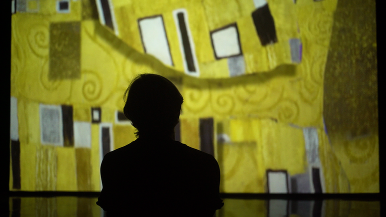 Silhueta observando 'O Beijo' de Klimt