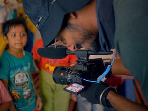 A documentary film crew at The Qurious Studio capturing a real moment during an NGO impact film shoot in India