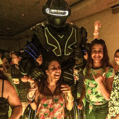 Várias crianças na festa da escola com robo dançando junto.