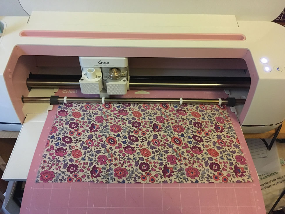 Cricut Maker with rotary blade loaded with pink fabric grip mat and fabric