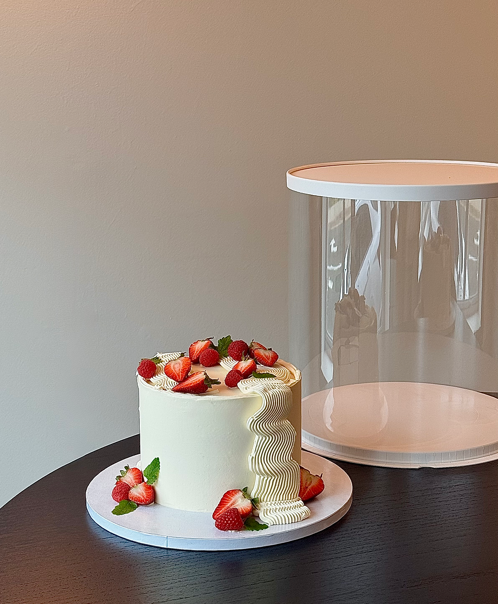 Elegant white cake decorated with fresh strawberries and piped cream details