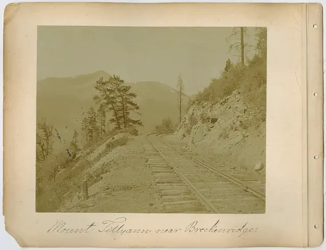 Sepia-toned photo of a mountain railway near Breckenridge. Tracks curve along a rocky landscape with trees. Text: "Mount Tillyann near Breckenridge".