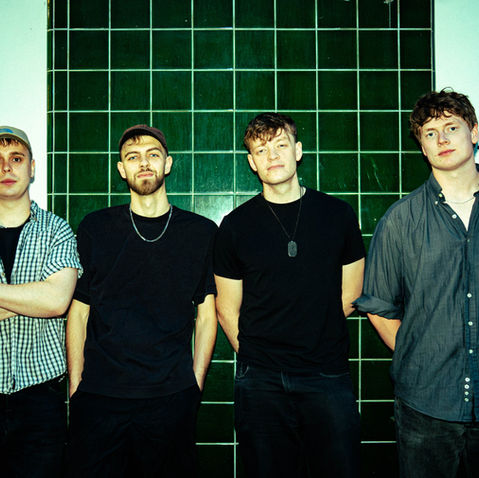FLOK stood against a wall as a Full Band