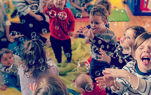 children playing on parachute catching bubbles