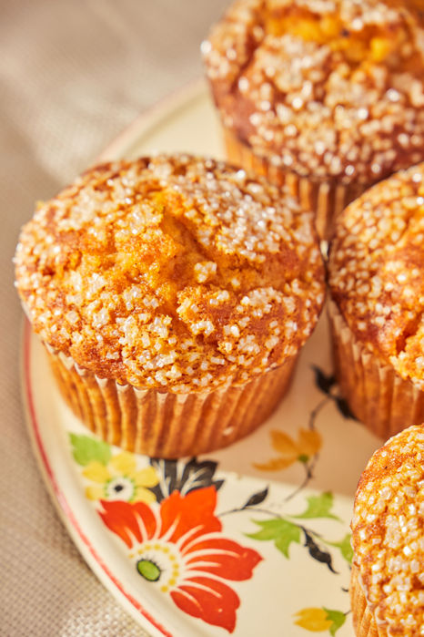 Close-up on plate of muffins topped with coarse sugar.