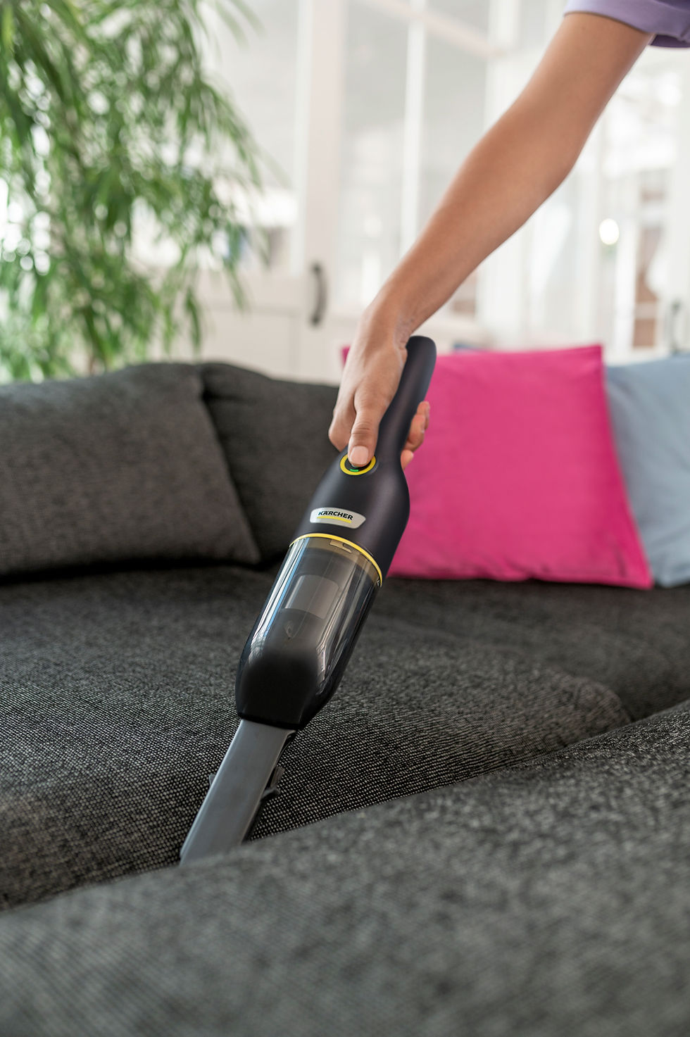 Thumbnail: Person vacuuming a gray couch with Kärcher AF 20, pink pillow and background.
