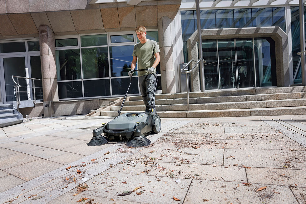 Thumbnail: Man operating a street sweeper outdoors on a stone patio, cleaning debris.