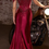 Thumbnail: A deep maroon or burgundy satin gown with a fitted bodice and mermaid skirt, posed next to a motorcycle.