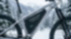 A close-up of an ebike battery fitted with a protective thermal neoprene cover in a snowy, winter riding environment