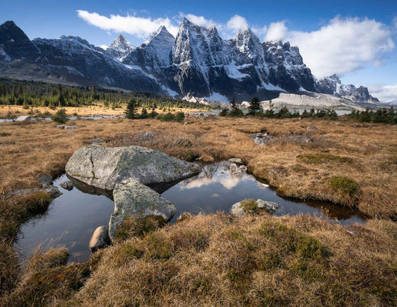 Snow-capped mountains reflect in a small pond, Jasper National Park. Devin Shaw Photography devinshots