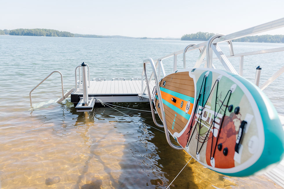 Paddleboard stored on LakeEze dock accessories by the water.