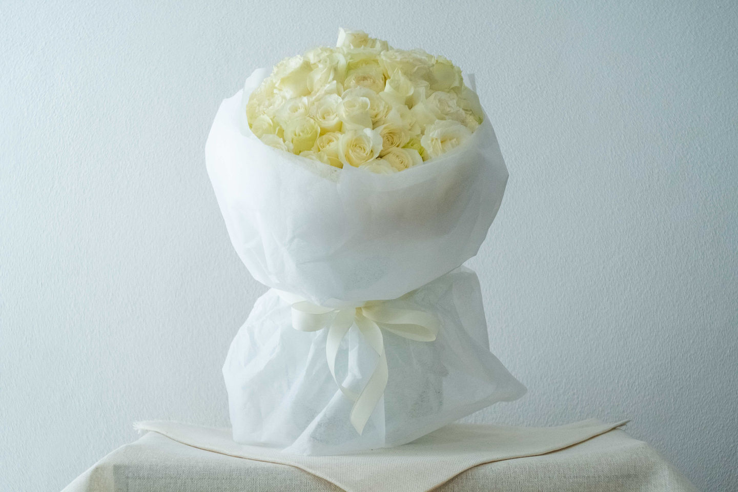 Ramo elegante, minimalista de 100 hermosas rosas blancas con pétalos abundantes, recién cortadas, de la florería Xanat Flores, una tienda de ramos y flores a domicilio en CDMX, México. Ideales para regalar o decorar.