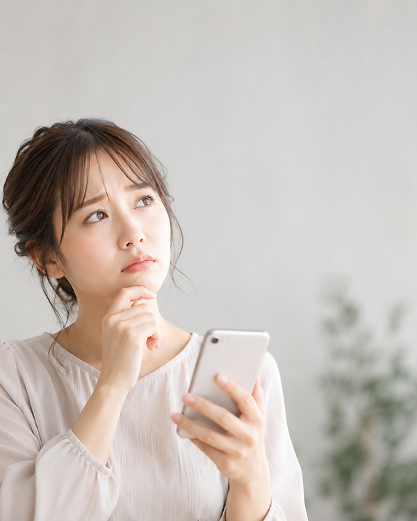 スマホを片手に上の空で悩んでいる女性