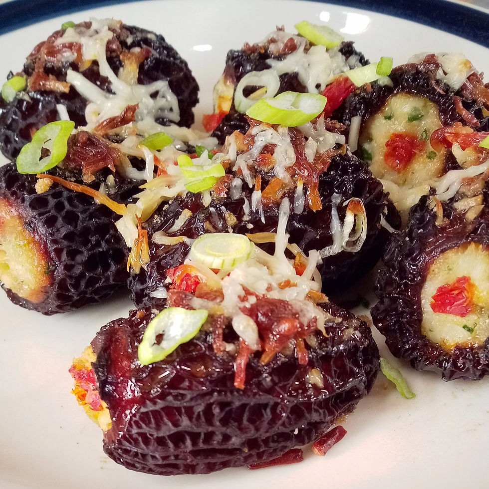 Wild harvested, crab stuffed morel mushrooms topped with a parmesan breadcrumb crust and green onion on white ceramic plate.