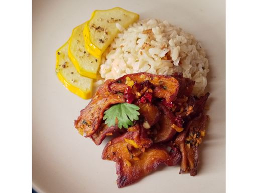 Wild harvested Spicy Garlic Butter Lobster mushrooms, risotto, seared yellow zucchini, cilantro, on a white ceramic plate.