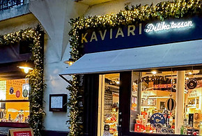 Décoration de Noël raffinée sur la façade de la boutique Kaviari Delikatessen à Paris 15e avec guirlandes dorées