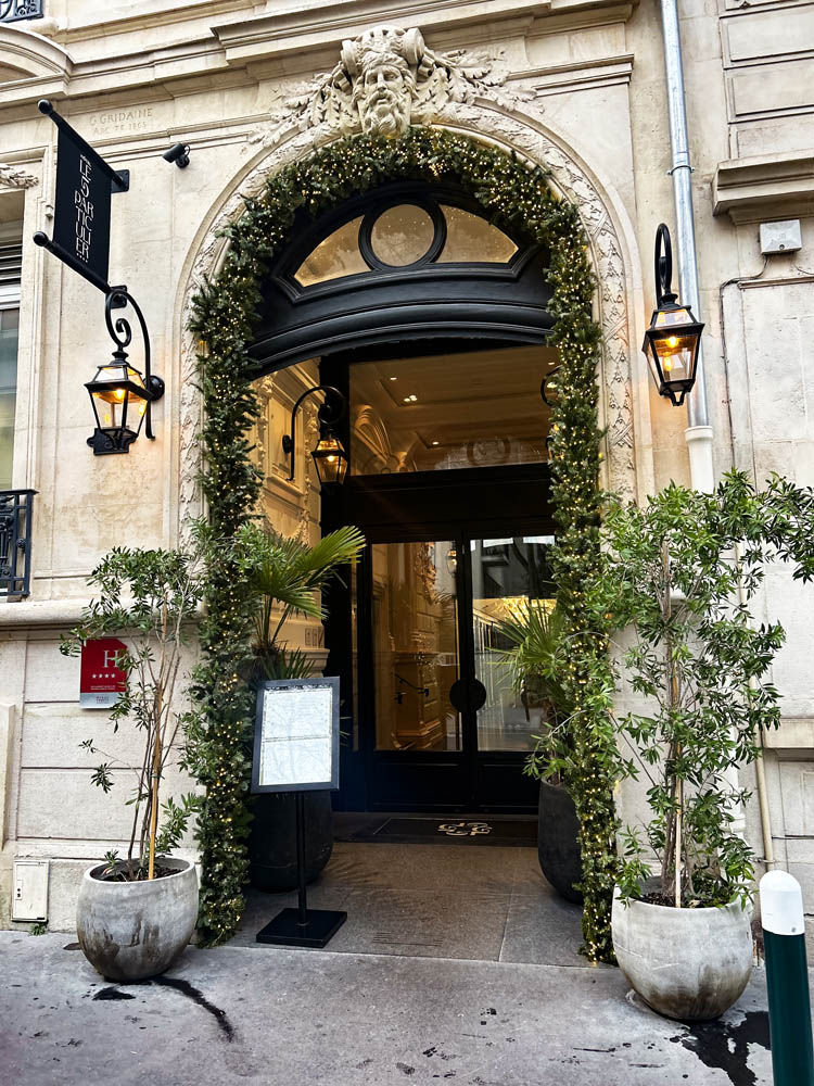 Décoration de Noël naturelle à l’entrée de l’Hôtel Le 5 Particulier à Neuilly, avec arche en sapin illuminée