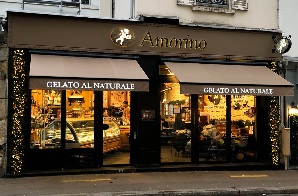 Décoration de Noël de la boutique Amorino à Paris 17e avec sapin naturel et guirlandes lumineuses sur les montants latéraux