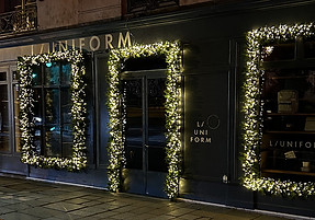 Guirlandes lumineuses blanches pour la façade de la boutique L/UNIFORM à Paris 7e pendant les fêtes de Noël