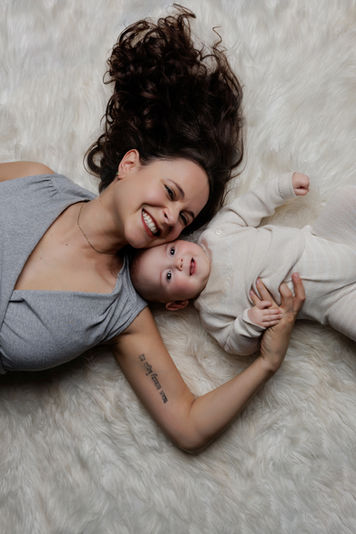 Mother lying with her baby during a calm Mother’s Day photo session