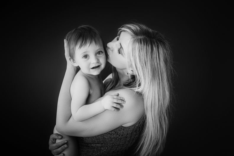 Black and white portrait of mother cuddling her young child